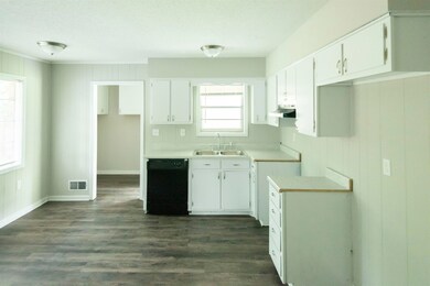 Kitchen with dishwasher, sink, and white cabinets