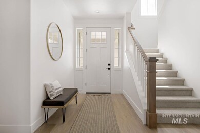 Entryway with light wood finished floors and stairs