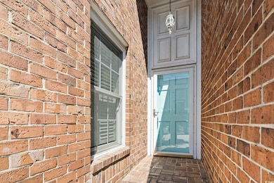 View of exterior entry featuring brick siding