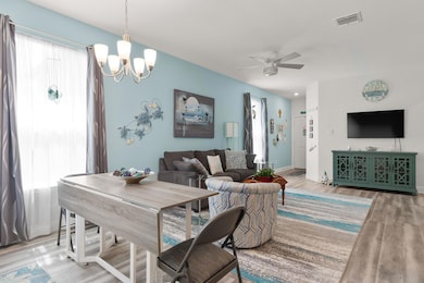 Living area with wood finished floors, a chandelier, and a ceiling fan