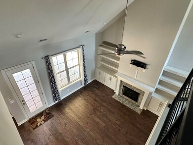 Unfurnished living room with ceiling fan, dark woo