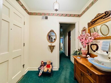 Corridor featuring dark colored carpet