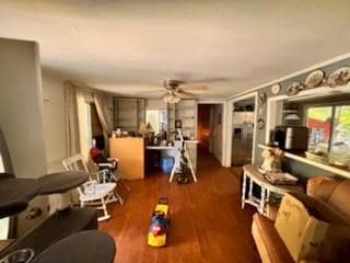 Living room with ceiling fan, wood finished floors, and plenty of natural light
