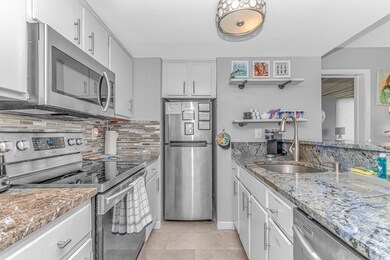 Kitchen featuring white cabinets, sink, light tile