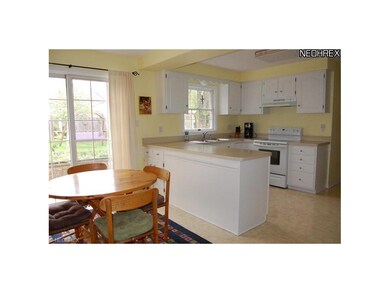 The bright kitchen offers white cabinetry and appl