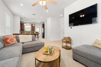 Living area featuring light carpet, a ceiling fan