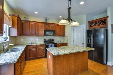 Large pantry in corner, wine rack over fridge, upgraded lighting, tumbled marble backsplash add luxurious finishes.