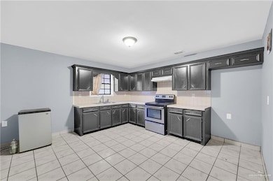 Kitchen featuring backsplash, light countertops, and electric stove