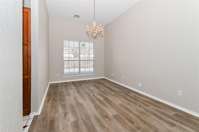 Empty room featuring lofted ceiling, hardwood / wood-style floors, and a chandelier