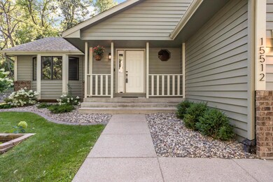 Gorgeous entryway with small sitting porch and concrete landscape edging.