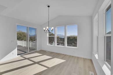 Unfurnished dining area featuring light wood-type flooring, lofted ceiling, a chandelier, and a mountain view