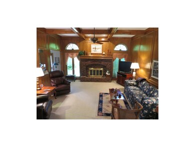 Family room features boxed beamed ceiling and wood
