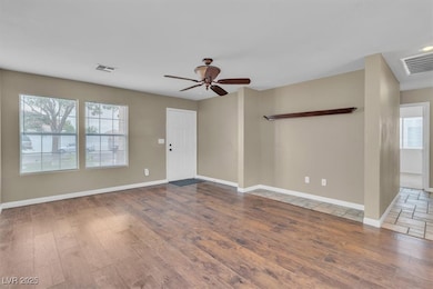 Unfurnished living room featuring plenty of natural light, ceiling fan, and wood finished floors