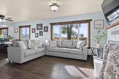 Living area featuring healthy amount of natural light, wood finished floors, and a ceiling fan