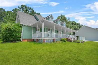 View of front of home with a porch, a front lawn, and a shingled roof