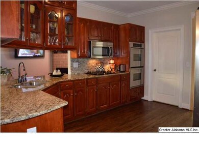 The kitchen has warm tone custom wooden cabinets. 