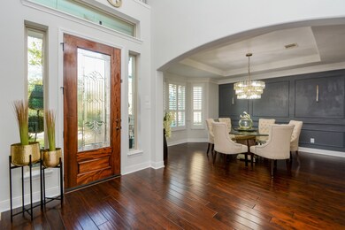 What a grand entrance this special home provides! Right off the entryway, natural wood floors stretch throughout and welcome whatever furnishings your lifestyle and comfort need! This space on the immediate left of the entry, is displayed here as a dining space. It's a beautiful choice. Yet, the area, with its front wall of windows and generous floor space, can be anything you desire. Arched doorways and artisan touches to windows framing the front door are rich nuances to this space.l