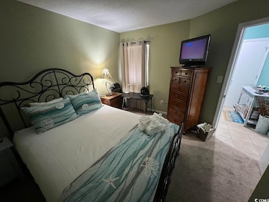 Carpeted bedroom featuring a textured ceiling