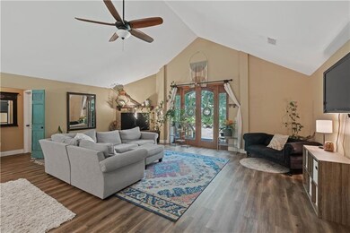 Living room featuring a ceiling fan, dark wood-sty