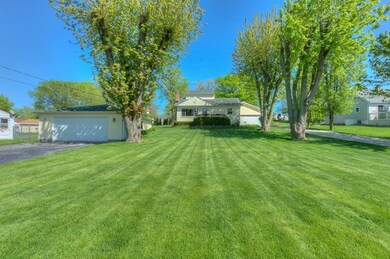FRONT OF THE HOUSE WITH DETACHED GARAGE AND ATTACHED GARAGE AND EXPANSIVE FRONT YARD