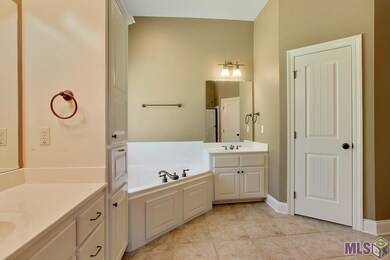 The master bathroom has double vanities, a large j