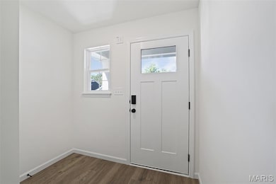 Entryway featuring dark wood-style floors and baseboards