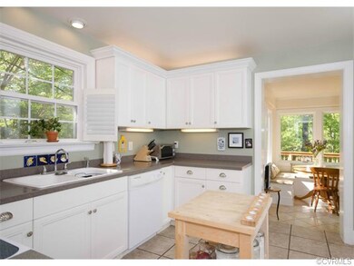 The kitchen is remodeled with white cabinetry, til