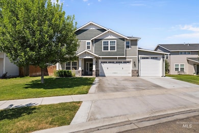 Craftsman-style house featuring driveway, stone siding, board and batten siding, a front yard, and a RV garage