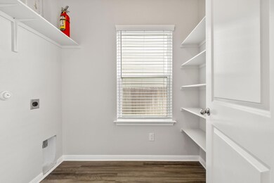 Washroom with electric dryer hookup, dark wood fi
