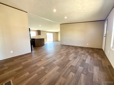 Unfurnished living room featuring a textured ceili