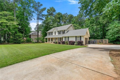 View of front of home with driveway, an attached garage, a front yard, roof with shingles, and covered porch