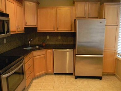 Kitchen. Ceramic tile floor and dark granite is a 