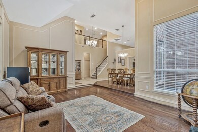 Living room featuring dark hardwood / wood-style floors, a towering ceiling, and an inviting chandelier