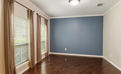 The formal study has french doors, wood flooring and floor to ceiling windows.