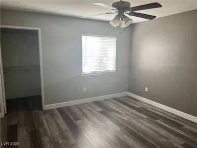 Primary bedroom with dark wood-style flooring, a c