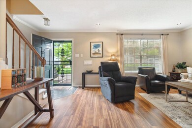 Living room with hardwood / wood-style flooring and ornamental molding