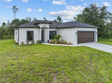 Prairie-style home with driveway, a garage, stucco siding, a front yard, and a shingled roof