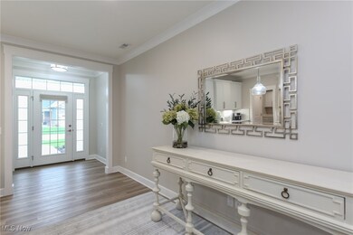 Foyer with ornamental molding and light wood finished floors