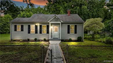View of front of property featuring a chimney, roo