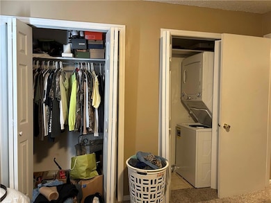 Closet featuring stacked washer and clothes dryer