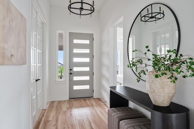 Entrance foyer with baseboards, a notable chandel