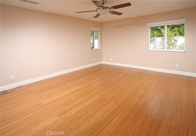 The expansive master suite is drenched in natural light and is further highlighted by a designer lighted ceiling fan, large walk-in closet and striking wood floors.