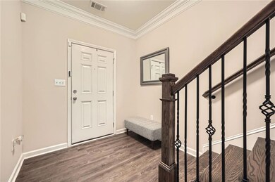 Foyer with wood finished floors, ornamental moldin