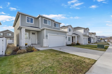 Traditional home featuring a residential view, driveway, a front yard, and stone siding