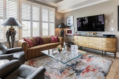 Living area with crown molding, wood finished floo