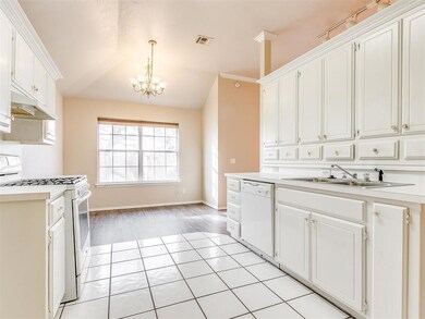 Kitchen with white appliances, a sink, a chandelier, light countertops, and lofted ceiling