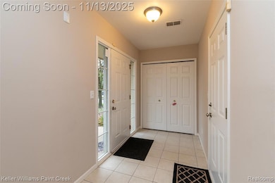Foyer with light tile patterned floors and baseboards