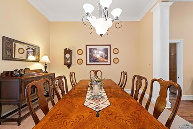 Dining room with a chandelier, crown molding, and ornate columns