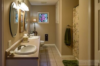 First bathroom with ceramic flooring, double vanit