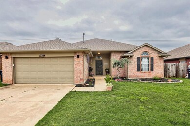Single story home featuring brick siding, roof with shingles, an attached garage, and concrete driveway